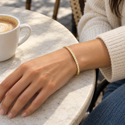 AI-generated lifestyle illustration of Lumière Slim Pavé Bangle – Gold-Tone Moissanite worn in an everyday setting.